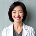 Dr. Chen, a female doctor, smiling and looking empathetic toward the camera, representing stress management